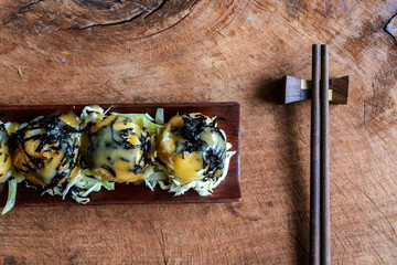 Takoyaki on wooden table with chopsticks, Japanese food