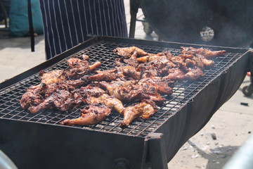 Chicken Portions Cooking on a Smokey Barbeque.