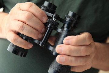 Man holds old pair of binoculars