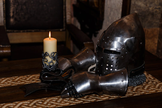 knight's helmet with visor and gloves on the table