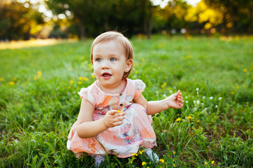Little girl sitting on the grass.