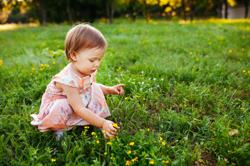 Little girl sitting on the grass.