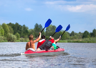 Young people are kayaking on a river in beautiful nature