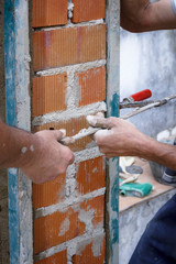 Obreros de la construcción trabajando en obra. Obras en el hogar. Reforma de fachada. Trabajador luciendo la fachada de una casa.