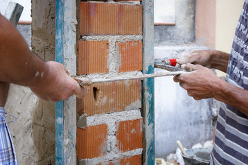 Obreros de la construcción trabajando en obra. Obras en el hogar. Reforma de fachada. Trabajador...