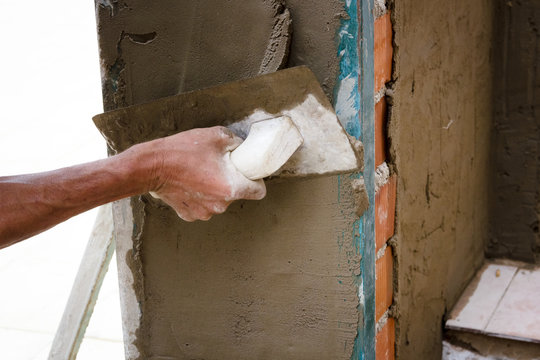 Obreros de la construcci&oacute;n trabajando en obra. Obras en el hogar. Reforma de fachada. Trabajador luciendo la fachada de una casa.
