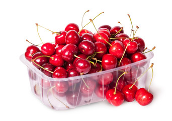 Fototapeta na wymiar Sweet cherries in plastic tray and three near top view