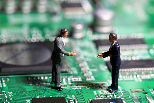 Miniature businessmen circuit board.
Miniature business figures standing on a circuit board.