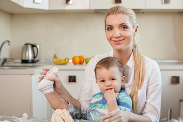Cheerful young mother and her child in kitchen
