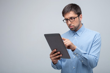 Cheerful young guy is working with internet