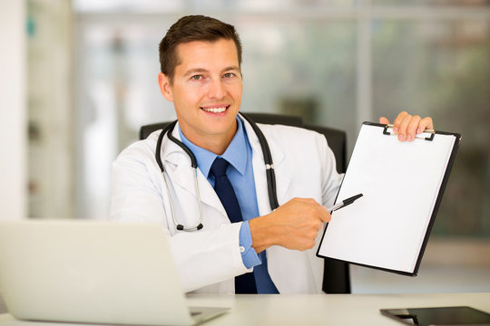 doctor showing clipboard with blank paper