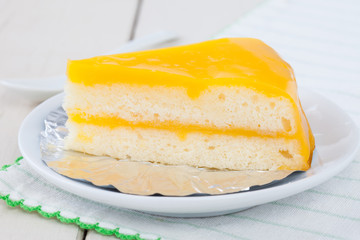 orange cake on white plate on wooden table