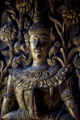Weathered carving of a Buddha on the door of a Buddhist temple 