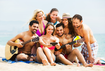 Adults with guitar at beach