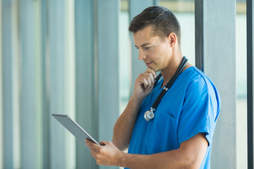 young medical intern using tablet computer at hospital