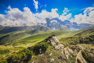 Fototapeta premium Rocky landscape of with ice peaks and blue cloudy sky in background , green valley , Ladakh, Jammu and Kashmir, India