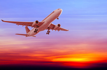 Commercial airplane flying at sunset