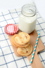 Breakfast set, glass of milk, snack on wooden plate