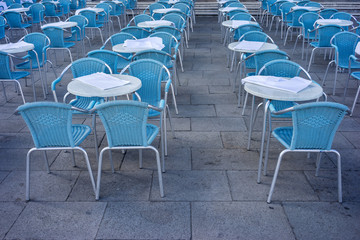 Metal tables and chairs in a cafe on the street
