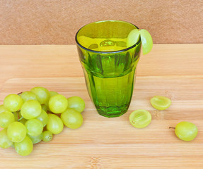 Green glass with juice and ripe grapes