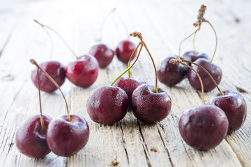 Cherries on wooden table with water drops