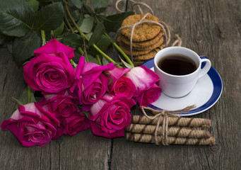 cup of coffee, cookies and bouquet of scarlet roses