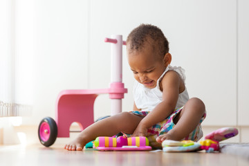 Portrait of little African American little girl sitting on the f