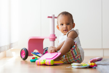 Portrait of little African American little girl sitting on the f