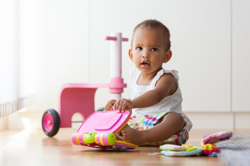 Portrait of little African American little girl sitting on the f