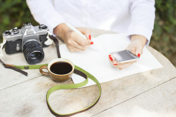 girl with cell phone, diary, cup of coffee and old camera