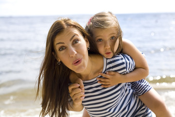 Fototapeta premium joyful and positive mother and daughter near the sea