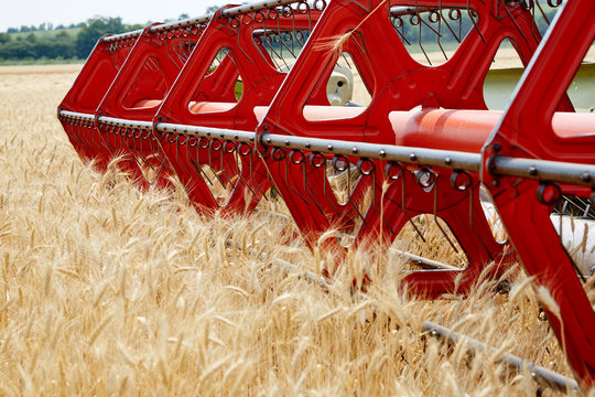An agricultural combine cutting and harvesting wheat in the fertile farm fields of Idaho.

