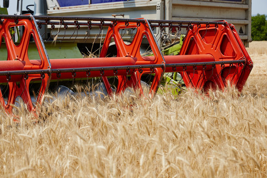 An agricultural combine cutting and harvesting wheat in the fertile farm fields of Idaho.
