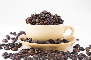 Cup full of coffee beans on on white background