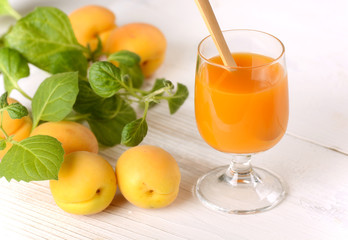 succo di albicocca sul tavolo bianco con frutta fresca intorno
