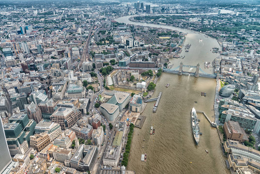 London. Helicopter View Of Tower Bridge Wiith Canary Wharf On Ba