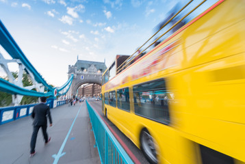 Blurred image of yellow bus fast moving along Tower Bridge