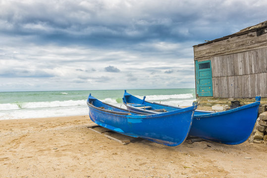 Blue boats on the seashore in a windy day