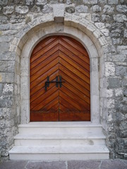 Fototapeta na wymiar Wooden arch doors at medieval castle in Budva