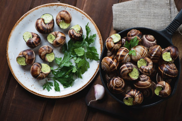 Uncooked snails with garlic butter and fresh parsley, above view