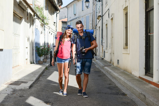 cheerful young couple backpacker traveling and sighseeing through europe during summer
