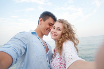 young couple beach doing selfie on the beach