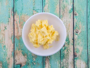 Fototapeten A bowl of margarine in white bowl over wooden background © akulamatiau