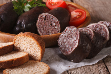 Fresh blood sausages and vegetables on a plate close-up. horizontal
