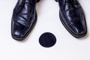 Standpunkt,Herrenschuhe stehen auf schwarzem Punkt