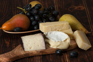 Assorted Cheese On Slate Stone. Grapes, Pears