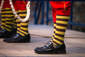 Uncommon man with stiped socks on stage