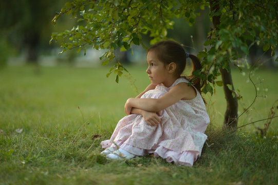 Little Girl Sitting Under  Tree