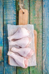 raw organic chicken legs on a cutting board