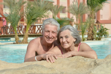 Fototapeta na wymiar Senior couple relaxing at pool